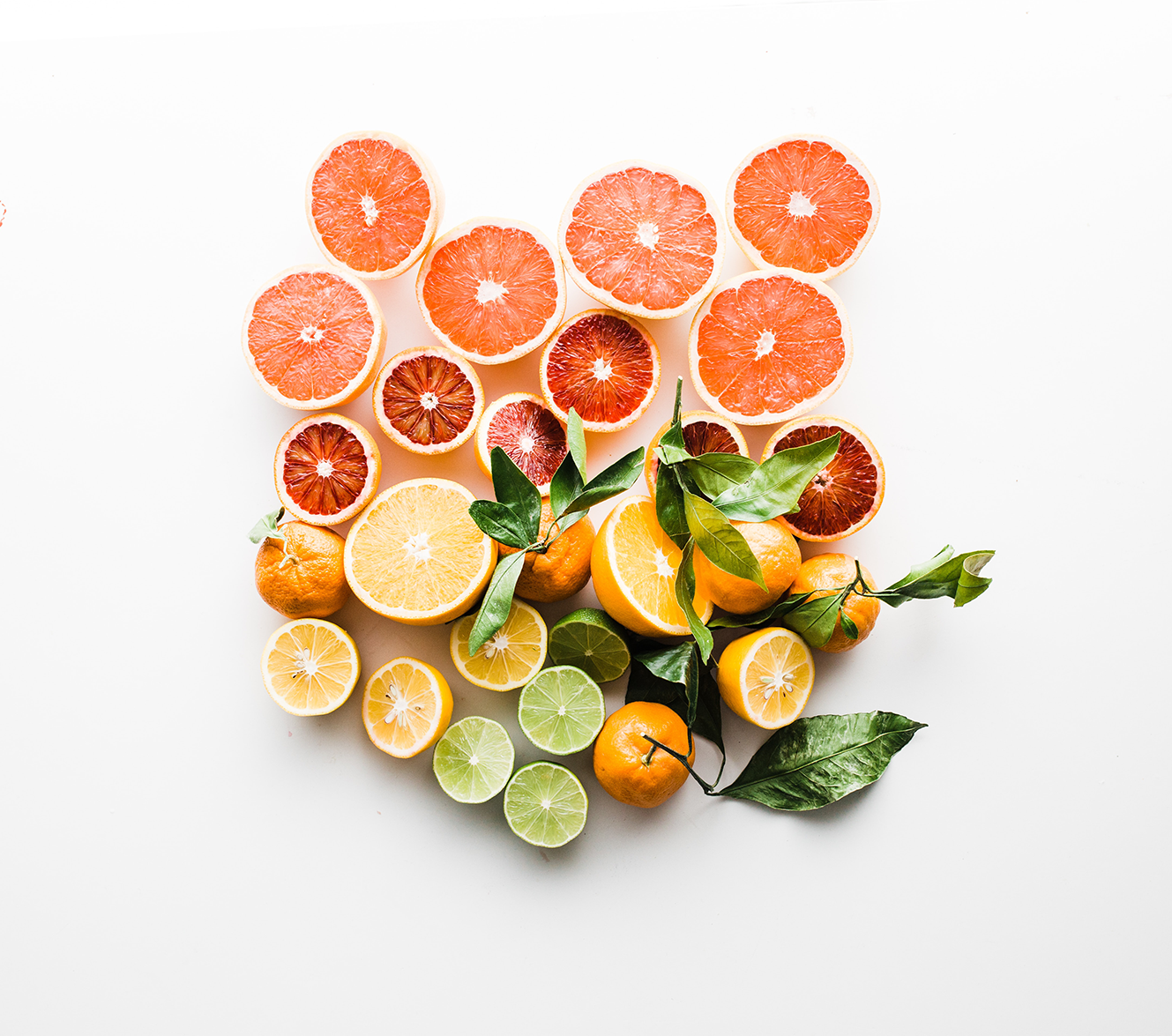 Assorted sliced citrus fruits on white background